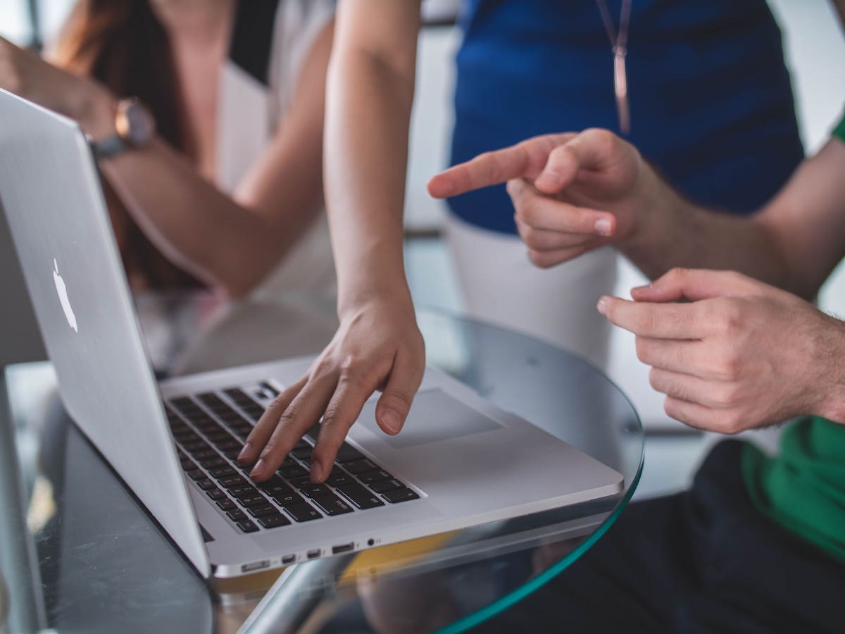 Photo of a hand resting on a Mac